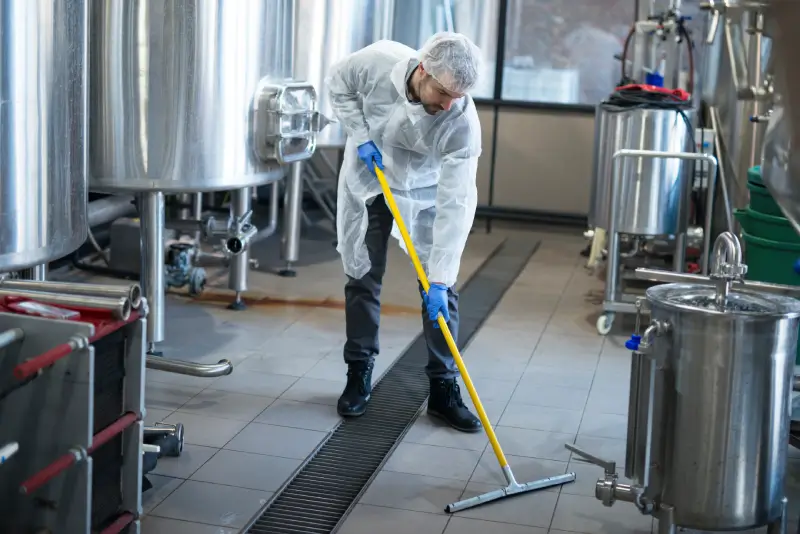 professional cleaner wearing protection uniform cleaning floor production plant 2